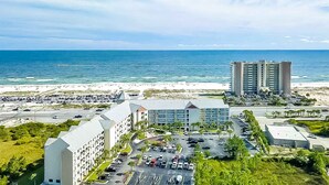 Ein Hotel mit Parkplatz, Strand und Meerblick.