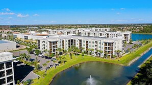 Un hôtel moderne à étages, doté d’une cour intérieure et bordé d’un plan d’eau.