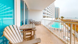 Ein Balkon mit Pool, Stühlen und einem Tisch.