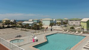 Ein Resort mit Swimmingpool, Liegestühlen und Blick auf den Ozean.