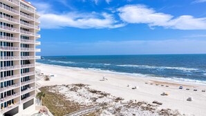 A beachfront hotel with multiple balconies, a sandy beach, and the ocean. - Beachfront condo with amazing views, multiple on-site pools & hot tubs (Gulf Shores)
