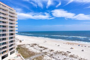 A beachfront hotel with multiple balconies, a sandy beach, and the ocean. - Beachfront condo with amazing views, multiple on-site pools & hot tubs (Gulf Shores)