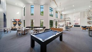 A modern indoor space with a pool table, seating areas, and large windows. - Landing | Beautiful 2BD, Clubhouse, Courtyard (Naples)