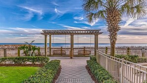 Un sendero empedrado que conduce a una pérgola con vistas al mar.