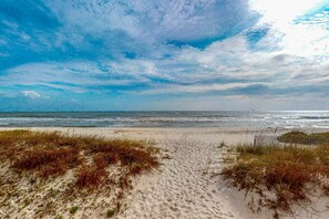 A beach with sand, seaweed, and a wooden fence. - Beach & Gulf-Front House with Beach Views, Balcony, Central AC (Fort Morgan)