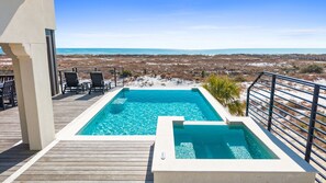 En swimmingpool med utsikt över stranden och havet.