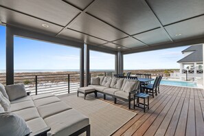 Ett takförsett utomhusområde med en pool, en soffa och ett matbord.