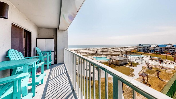 Ein Balkon mit Blick auf Strand und Poolbereich.