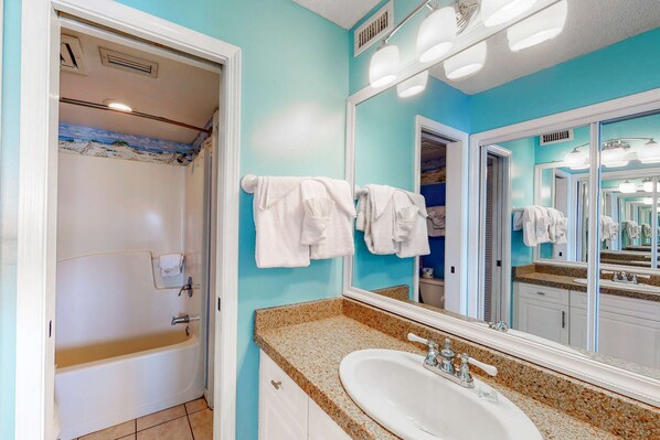 A bathroom with a bathtub, a sink, and a large mirror. - Oceanfront condo with Gulf-view balcony, beach access, pool, WiFi, & central AC (Fort Morgan)