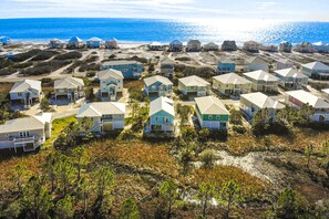 Un quartier résidentiel situé sur la côte, avec des maisons, une plage et une vue dégagée sur l’océan.