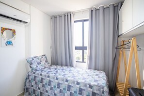 A bedroom with a bed, a window with curtains, a wall-mounted air conditioner, and a wooden ladder. - Park Del Prado #205 -ape em Cabedelo by Carpediem (Cabedelo)
