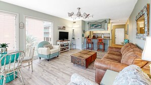 A living room with a sofa, a coffee table, and a television. - Centrally Located Oasis | Pool & Covered Balcony | Walk 1 Block to Beach (Gulf Shores)