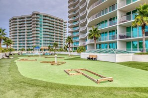 A hotel with multiple floors, outdoor pool, and palm trees. - Brilliant water view condo with multiple pools, lazy river & internet (Orange Beach)