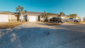 A residential street with houses, a driveway, and parked vehicles. - Dog-Friendly Condo with Shared Pool, Central AC, & Free High-Speed WiFi (Gulf Shores)