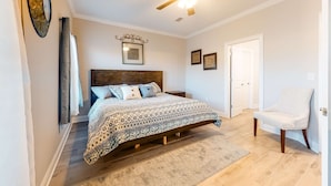 A bedroom with a bed, a ceiling fan, a door, and a chair. - Dog-Friendly Condo with Shared Pool, Central AC, & Free High-Speed WiFi (Gulf Shores)