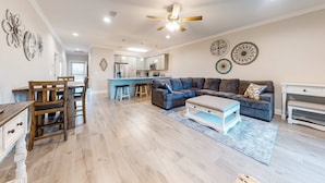 A spacious living area with a sofa, coffee table, and dining table. - Dog-Friendly Condo with Shared Pool, Central AC, & Free High-Speed WiFi (Gulf Shores)
