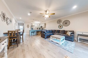 A spacious living area with a sofa, coffee table, and dining table. - Dog-Friendly Condo with Shared Pool, Central AC, & Free High-Speed WiFi (Gulf Shores)