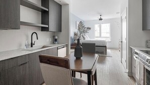 Een moderne keuken met een eethoek, een bed en een badkamer.