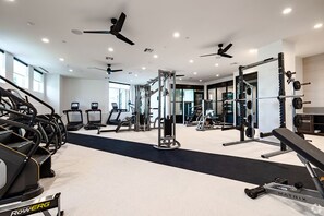 Une salle de sport moderne équipée de tapis de course, d’appareils de musculation et de poids libres.