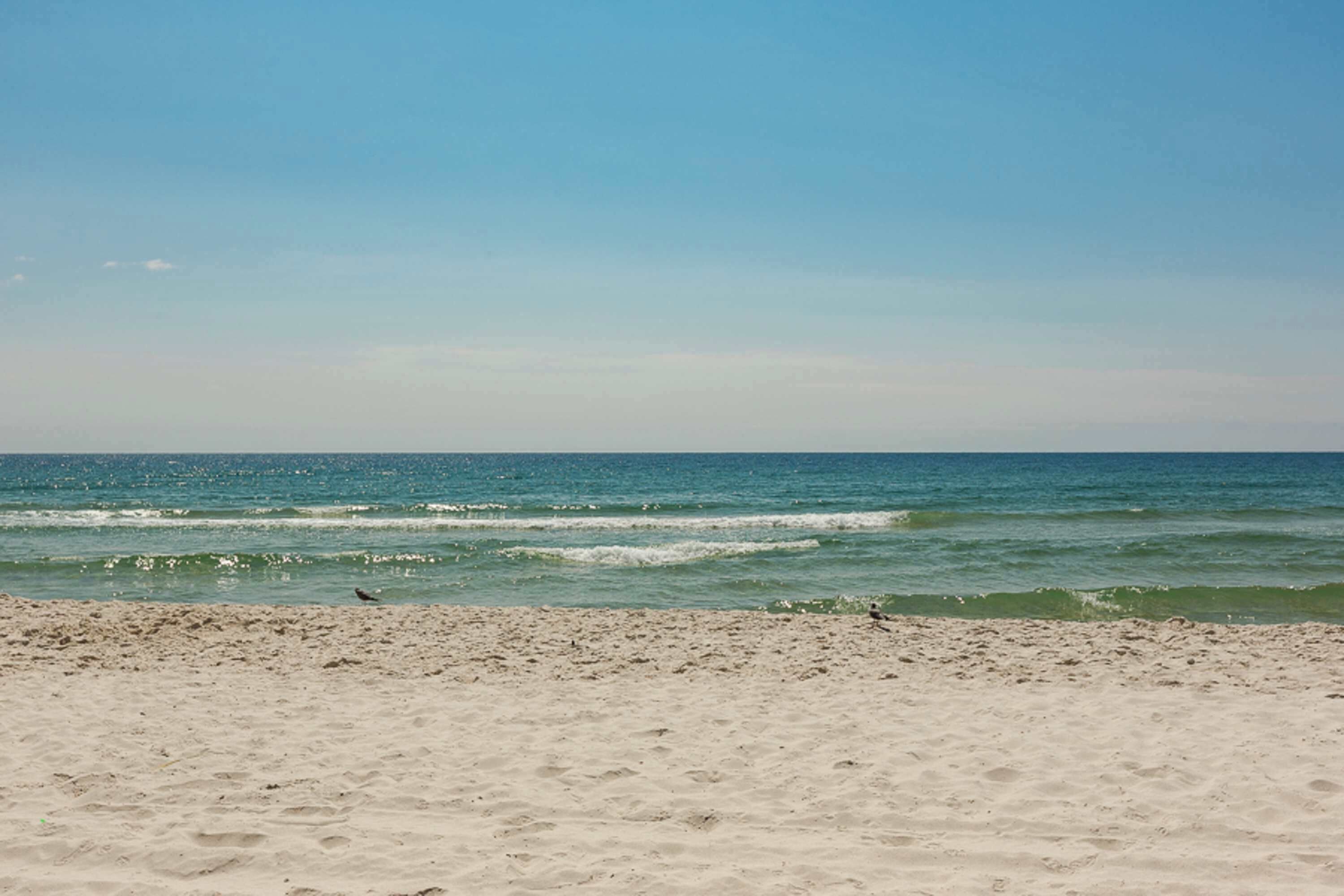 Ein Strand mit Sand und Meereswellen.