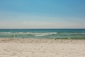 A beach with sand and ocean waves. - Spacious, Gulf-front vacation home with covered deck & beach access (Gulf Shores)