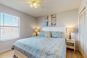 A bedroom with a bed, two bedside tables, a ceiling fan, and artwork on the wall. - Spacious, Gulf-front vacation home with covered deck & beach access (Gulf Shores)