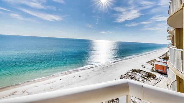 Ein Balkon mit Blick auf Strand und Meer.