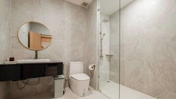 Ein Badezimmer mit Toilette, Waschbecken, Spiegel und Dusche.