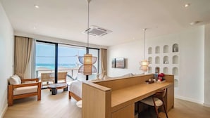 A modern hotel room with a balcony, a wooden desk, a sofa, and a bed. - Théo Privé Kohlarn (Koh Lan)