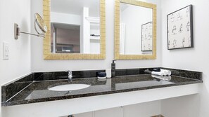 Uma casa de banho com uma pia dupla, um espelho, um porta-toalhas e uma moldura na parede.