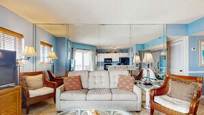 Ein Wohnzimmer mit einer Couch, zwei Sesseln, einem Couchtisch und einem Fernseher.