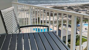 En balkong med utsikt över stranden och en pool.