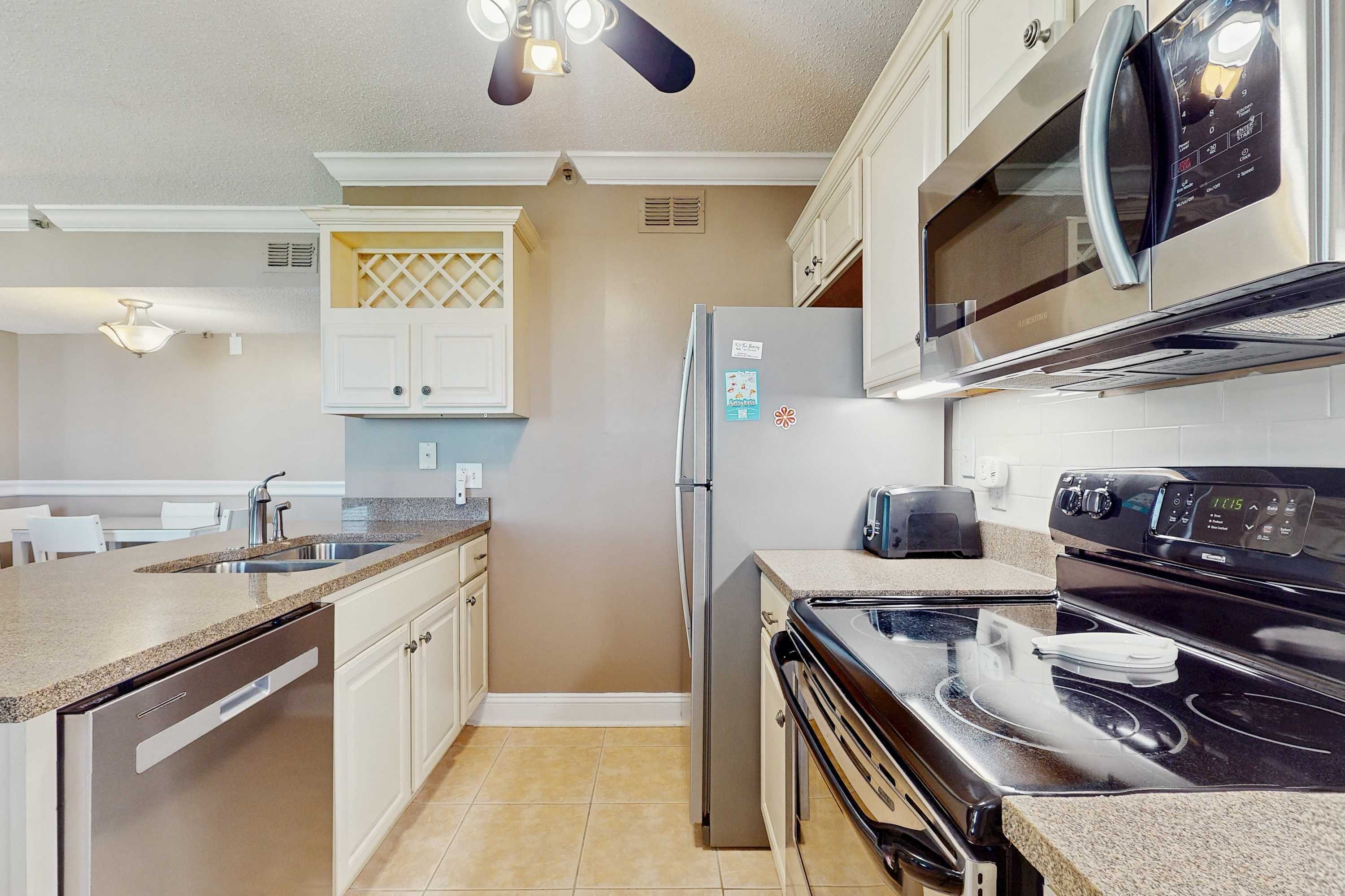 A modern kitchen with stainless steel appliances, a built-in microwave, and a dishwasher.
