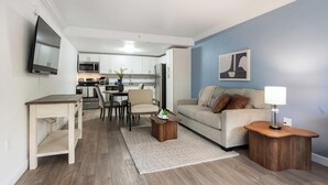 Un salon moderne comprenant un canapé, une table basse et un coin repas avec des chaises et une table.