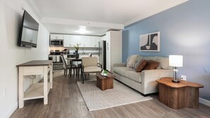 Ein modernes Wohnzimmer mit einer Couch, einem Couchtisch und einem Essbereich mit Stühlen und Tisch.