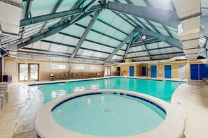 Ein Hallenbad mit hoher Decke, blauen Fliesen und einem Oberlichter.