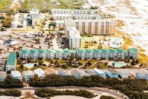 Ein Küstenhotel mit mehreren Gebäuden, einem Parkplatz und einem Strandabschnitt.