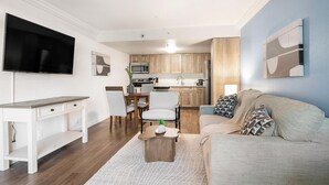 Un espai habitable compacte amb zona de menjador, petita cuina i sofà.
