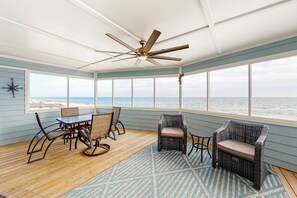 A covered outdoor area with a table and chairs, a ceiling fan, and a view of the ocean. - Beachfront Home w/Spacious Deck, Gas Grill, Free WiFi, Incredible Views, A/C (Fort Morgan)