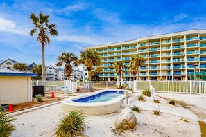 Ein Hotel mit mehreren Balkonen, einem Swimmingpool und Palmen.