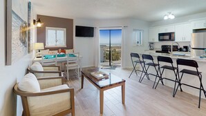 Een modern appartement met een woonkamer, eetgedeelte, keuken en een balkon met uitzicht.
