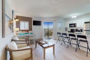 Ein modernes Apartment mit Wohnzimmer, Essbereich, Küche und einem Balkon mit Blick.