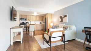 Un espacio habitable compacto con kitchenette, comedor y sofá.