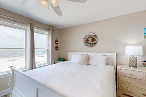 Een slaapkamer met een bed, nachtkastje, lamp en een decoratie aan de muur.