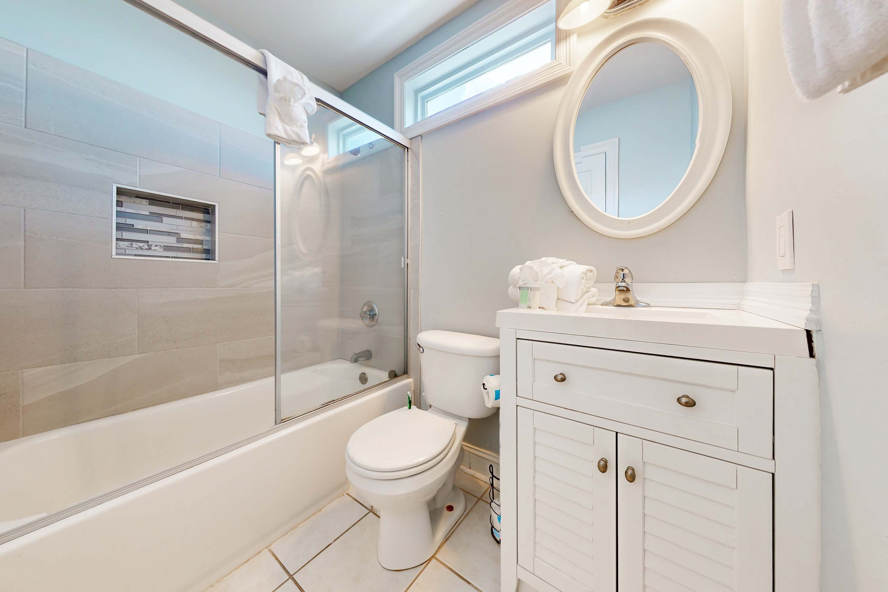 Une salle de bain équipée d’une baignoire, de toilettes et d’un meuble-lavabo avec des tiroirs.