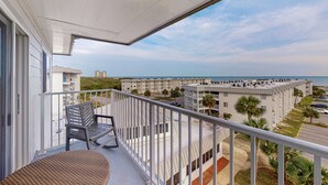 Ein Balkon mit Blick auf Strand und Gebäude.