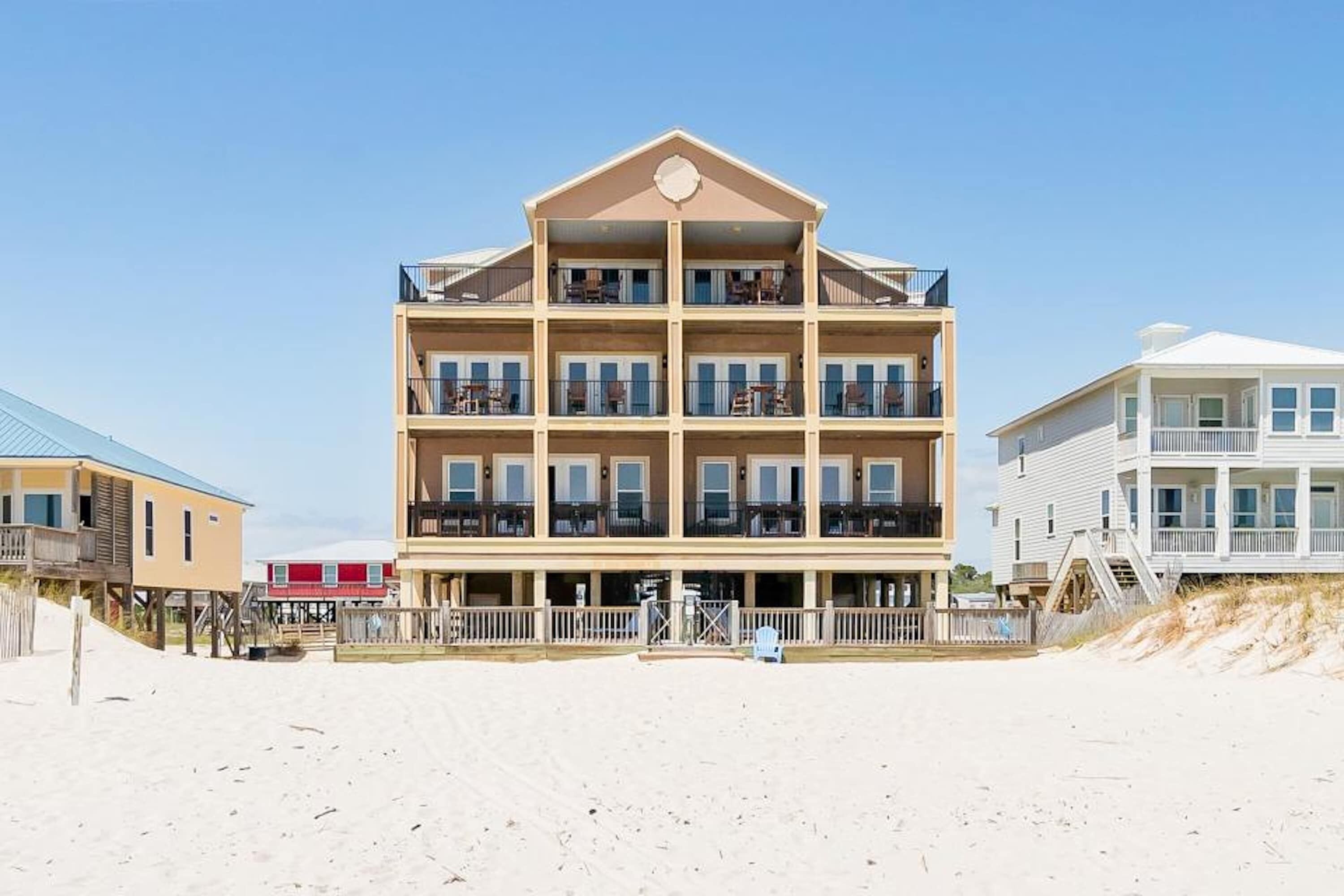 A multi-story beachfront hotel with balconies, a beachside location, and a simple architectural design.