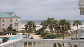 Ein Hotel mit Pool, Palmen und Blick auf den Strand.
