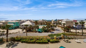 Un quartier résidentiel situé sur la côte, avec des maisons, une plage et une piscine.