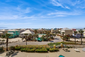 A coastal residential area with houses, a beach, and a pool.